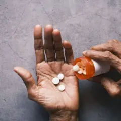 Dłoń wysypuje tabletki z buteleczki. Zastanawiasz się, tylenol co to? To lek przeciwbólowy.