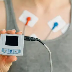 Holter co to? Urządzenie do monitorowania pracy serca z elektrodami na klatce piersiowej i małym rejestratorem w dłoni.