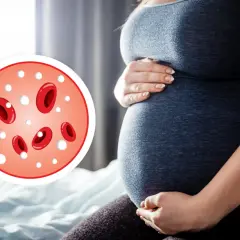 Ciężarna kobieta trzymająca się za brzuch, obok okrągły wykres z czerwonymi krwinkami i białymi kropkami.