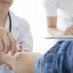 Lekarz aplikuje maść na rękę pacjenta, który otrzymał receptę na Auroverin MR.