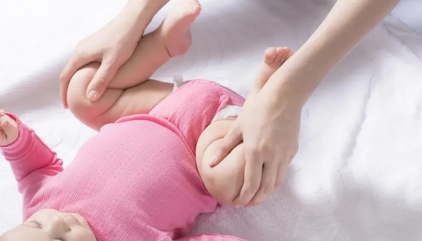 Delikatne ruchy dłoni rodzica pomagają w prawidłowym rozwoju stawów biodrowych dziecka, zapobiegając dysplazji.
