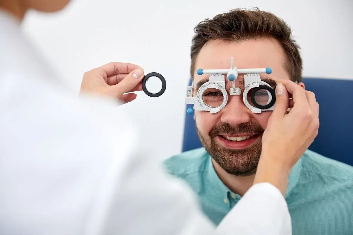 Mężczyzna w okularach próbnych podczas badania wzroku u optometrysty.