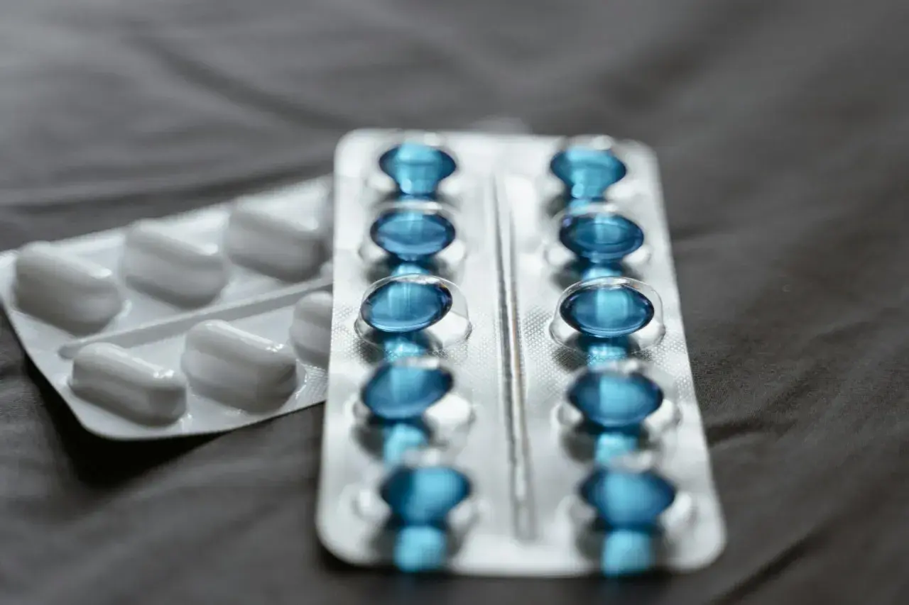 Dwa blistry leków: jeden z białymi kapsułkami, drugi z niebieskimi, prawdopodobnie pregabalin zentiva.