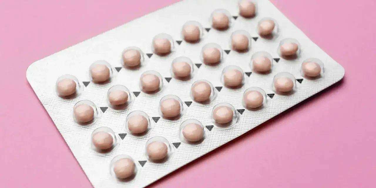 Blister opakowania tabletek antykoncepcyjnych, które mogą zapewnić orlifique. Różowe tabletki w srebrnym opakowaniu na różowym tle.